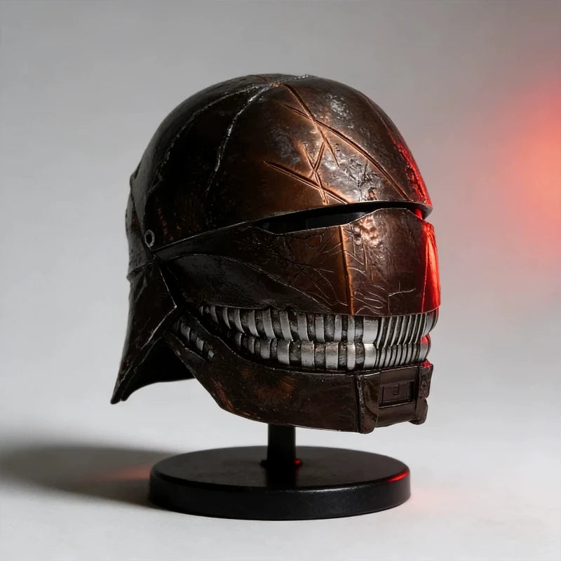 Casco metálico decorativo Star Wars con visor rojo y acabado envejecido, sobre base