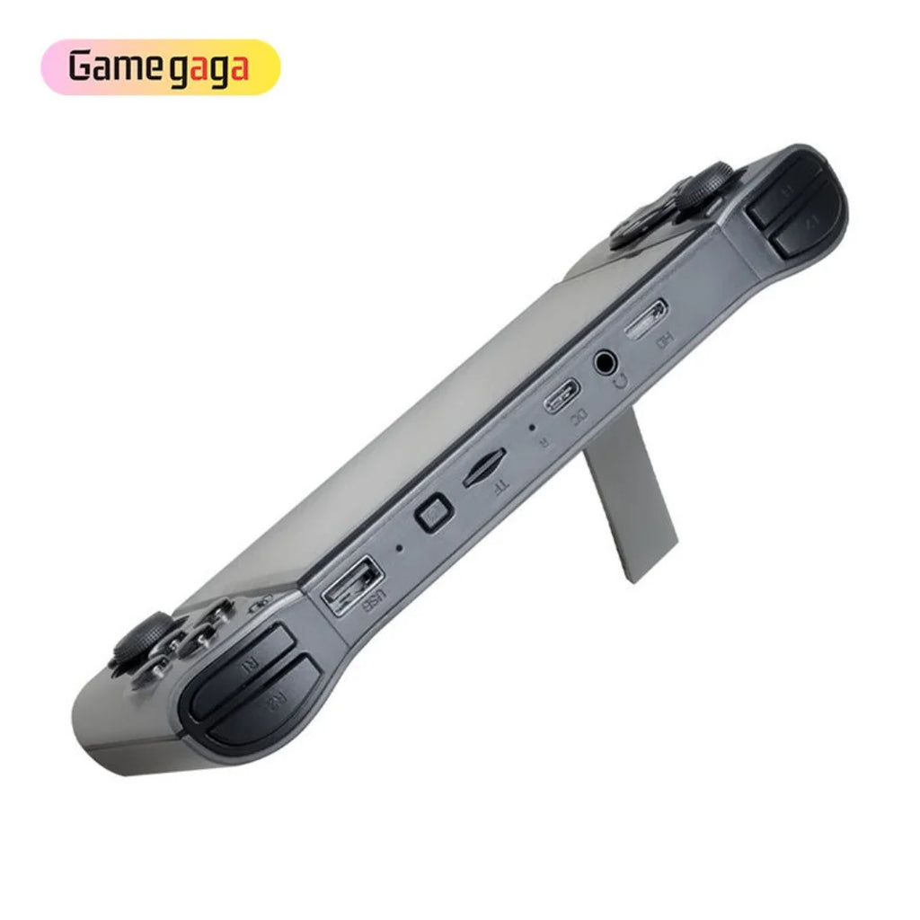 Consola portátil gris con botones superiores y puertos laterales visibles