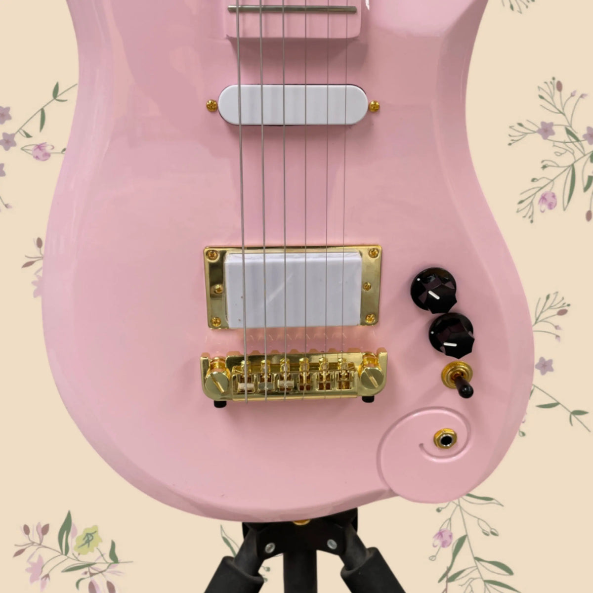 Guitarra eléctrica rosa con diseño de cabeza en espiral, elegante y moderna, con pastillas S+H y puente dorado fijo. La guitarra ideal para las jóvenes que están empezando.