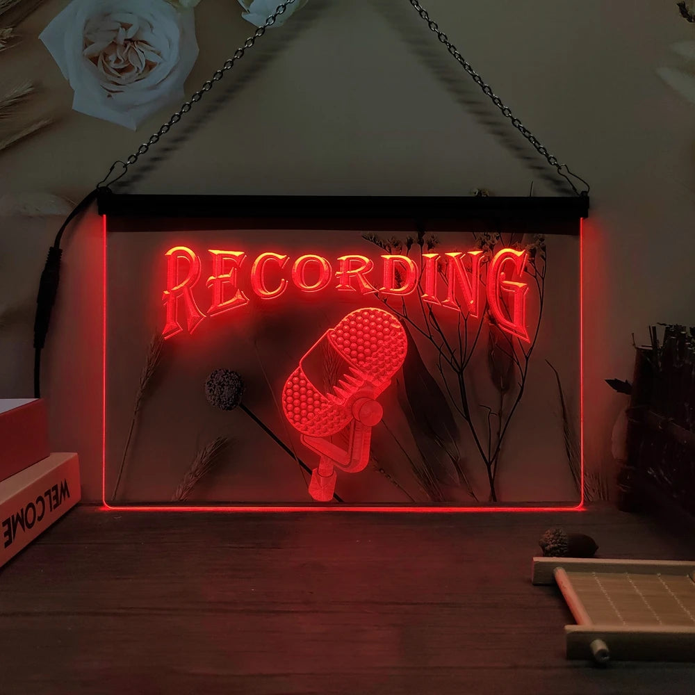 Letrero LED neón colgante con texto «RECORDING» y micrófono, luz roja.