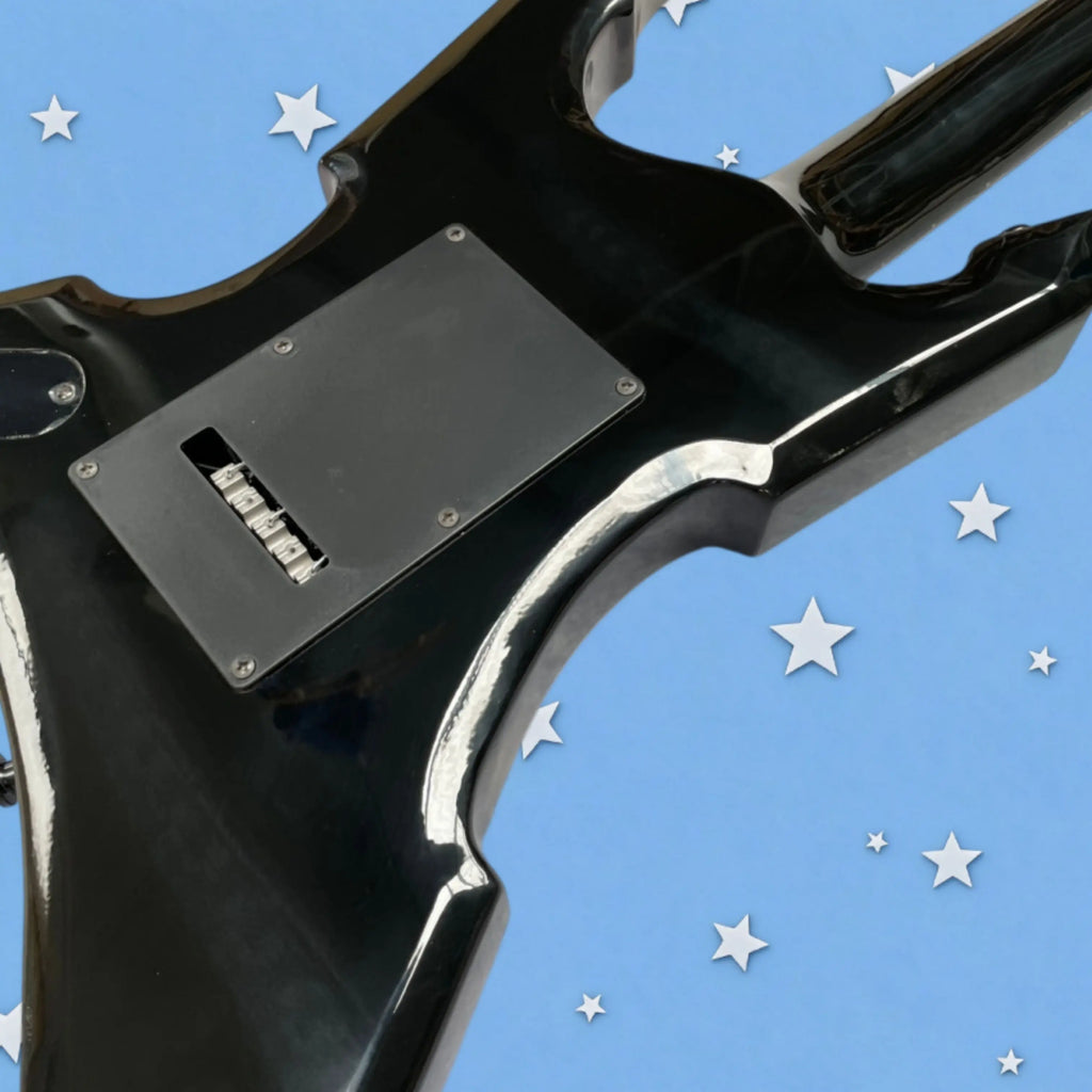 Guitarra eléctrica de diseño angular y color negro intenso, con herrajes completamente negros, pastillas HH, una guitarra de metal distinguida.