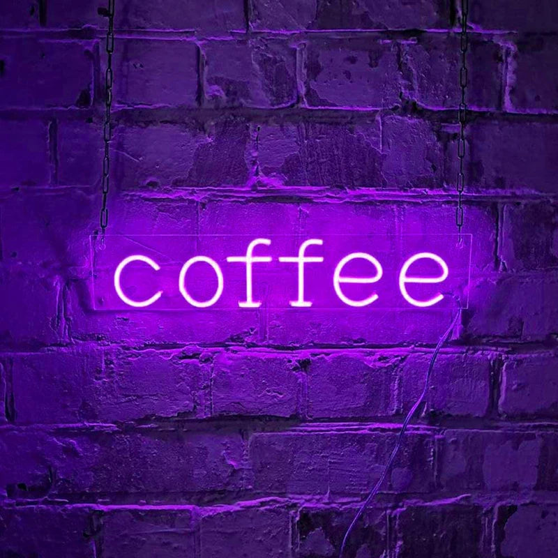 Letrero LED de neón con texto “coffee” en luz morada sobre pared de ladrillo.