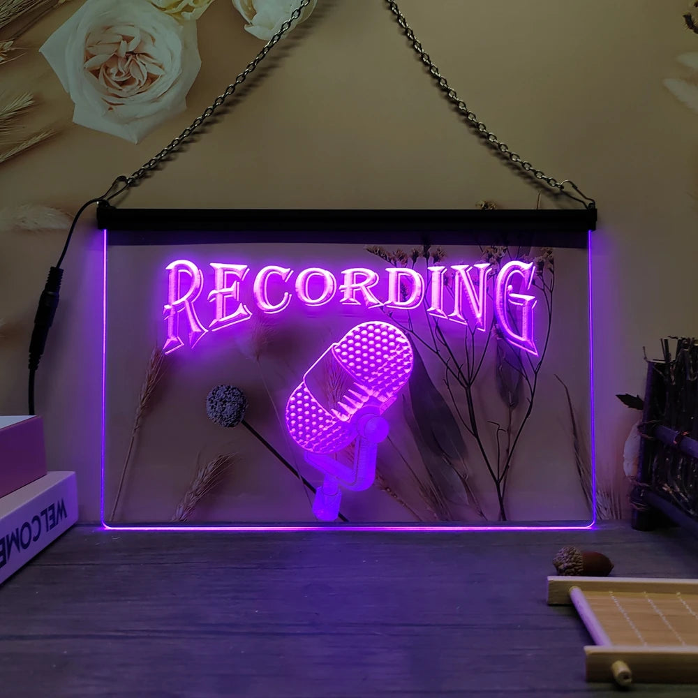 Señal de neón LED 'RECORDING' con borde morado y micrófono retro iluminado.