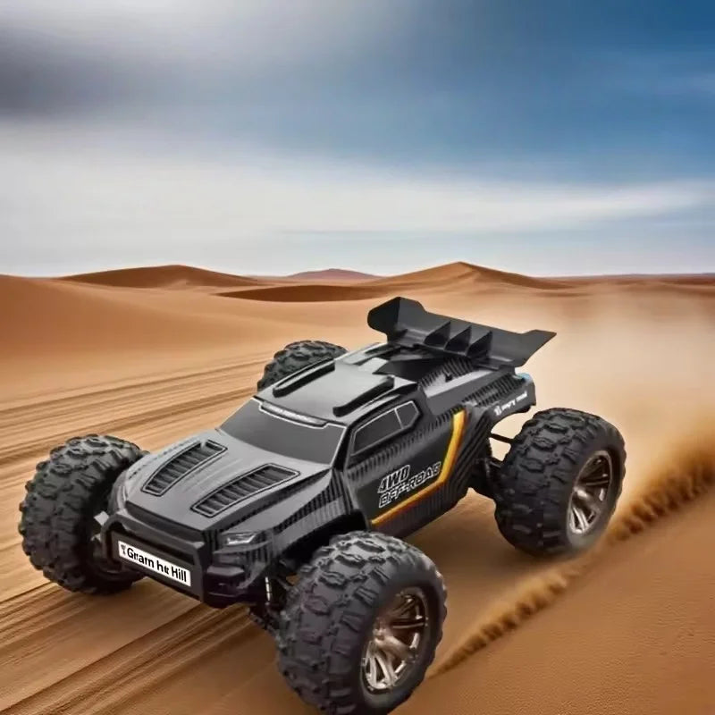 Coche RC todoterreno 4WD gris y negro en dunas, ruedas con tacos