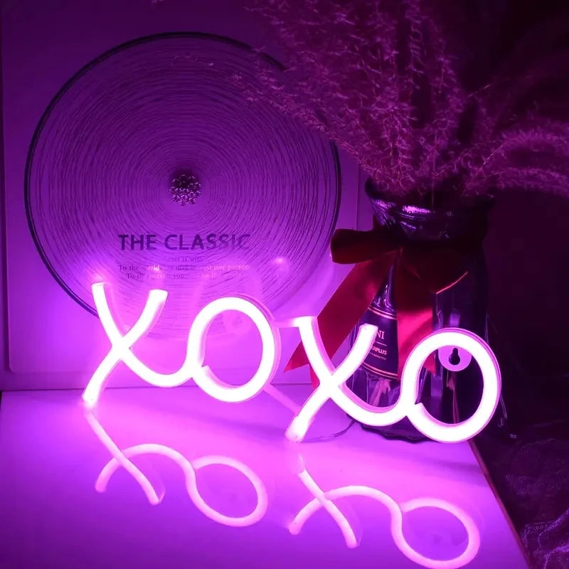 Letrero LED XOXO rosa encendido con letras y corazones en forma de nube