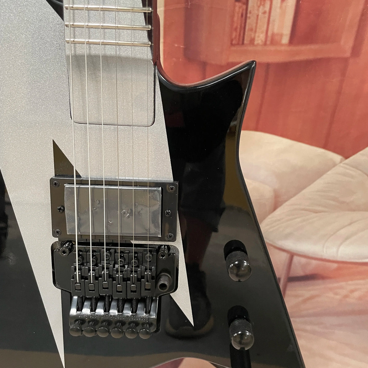 Guitarra eléctrica de 6 cuerdas, cuerpo negro con acabado plateado-gris, guitarra eléctrica con pastillas de doble bobina, guitarra eléctrica de forma única y no convencional.