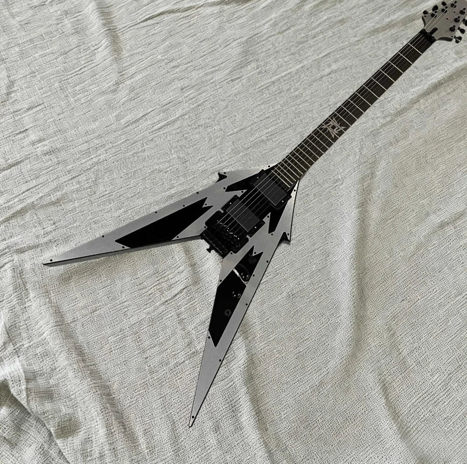 Guitarra eléctrica con forma de V, diseño geométrico en color plateado y negro, placa frontal de aluminio, puente con sistema de trémolo, pastillas HH, herrajes negros.