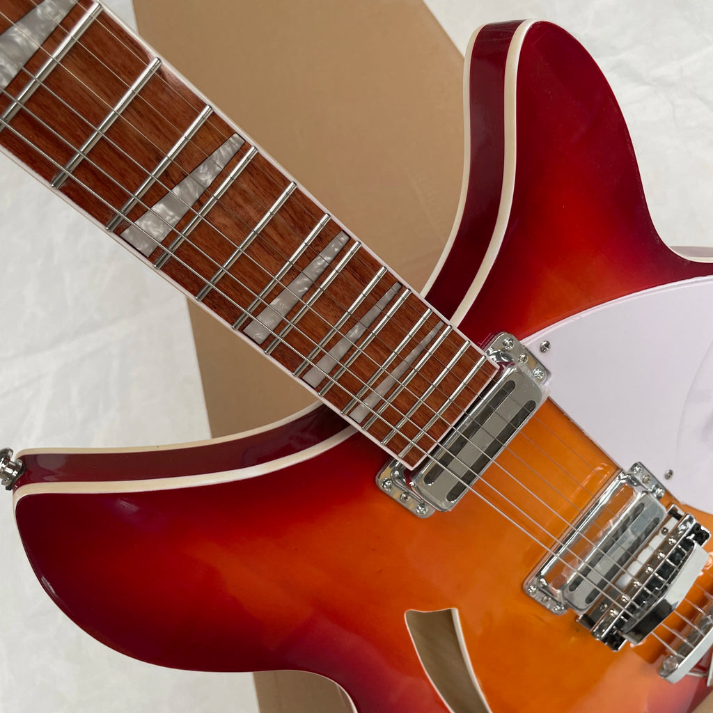 Guitarra eléctrica de 6 cuerdas, cuerpo semi-hueco con degradado de atardecer, pickguard blanco, perillas de volumen negras, guitarra para presentaciones en escenario.