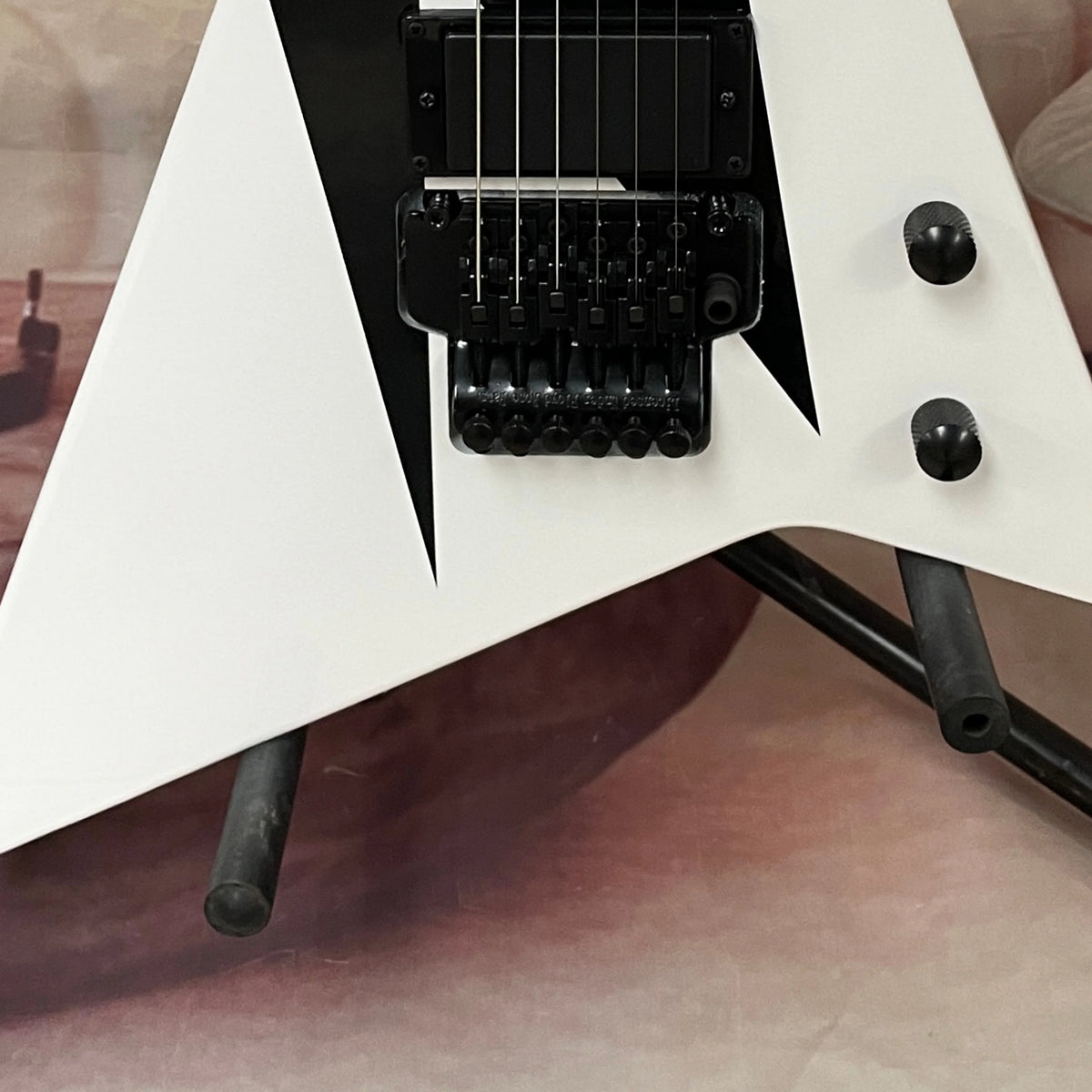 Guitarra eléctrica de 6 cuerdas con acabado en blanco y negro, cuerpo de caoba, herrajes negros —ideal para presentaciones en escenario.