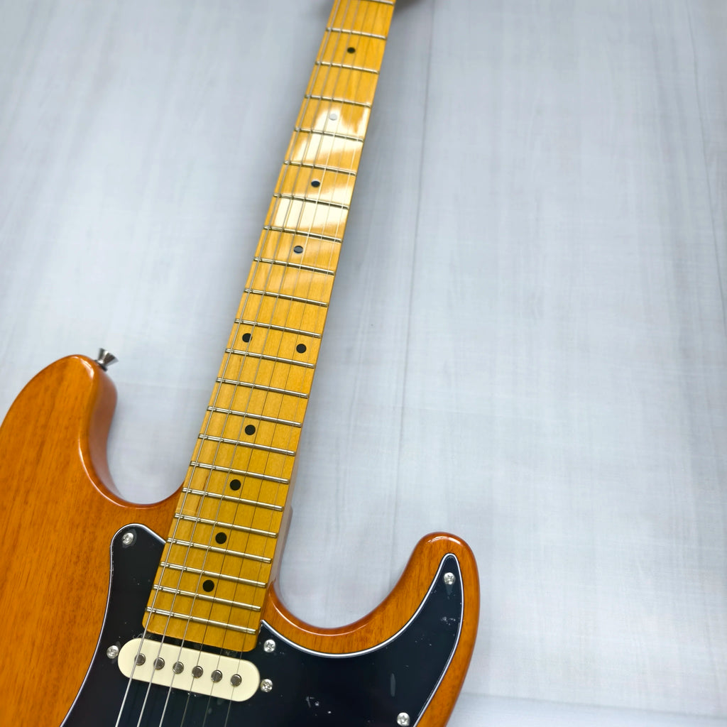 Guitarra eléctrica de madera natural con diapasón de arce, guardapalos negro SSS, bobina y trémolo. En stock.