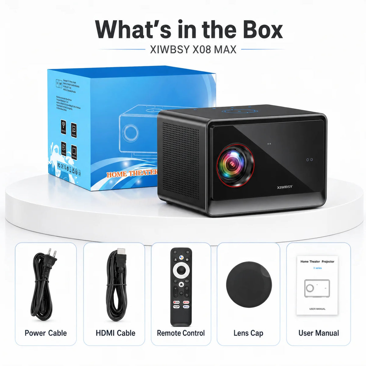 Proyector de cine negro con caja azul y accesorios: cables, mando y tapa de lente.
