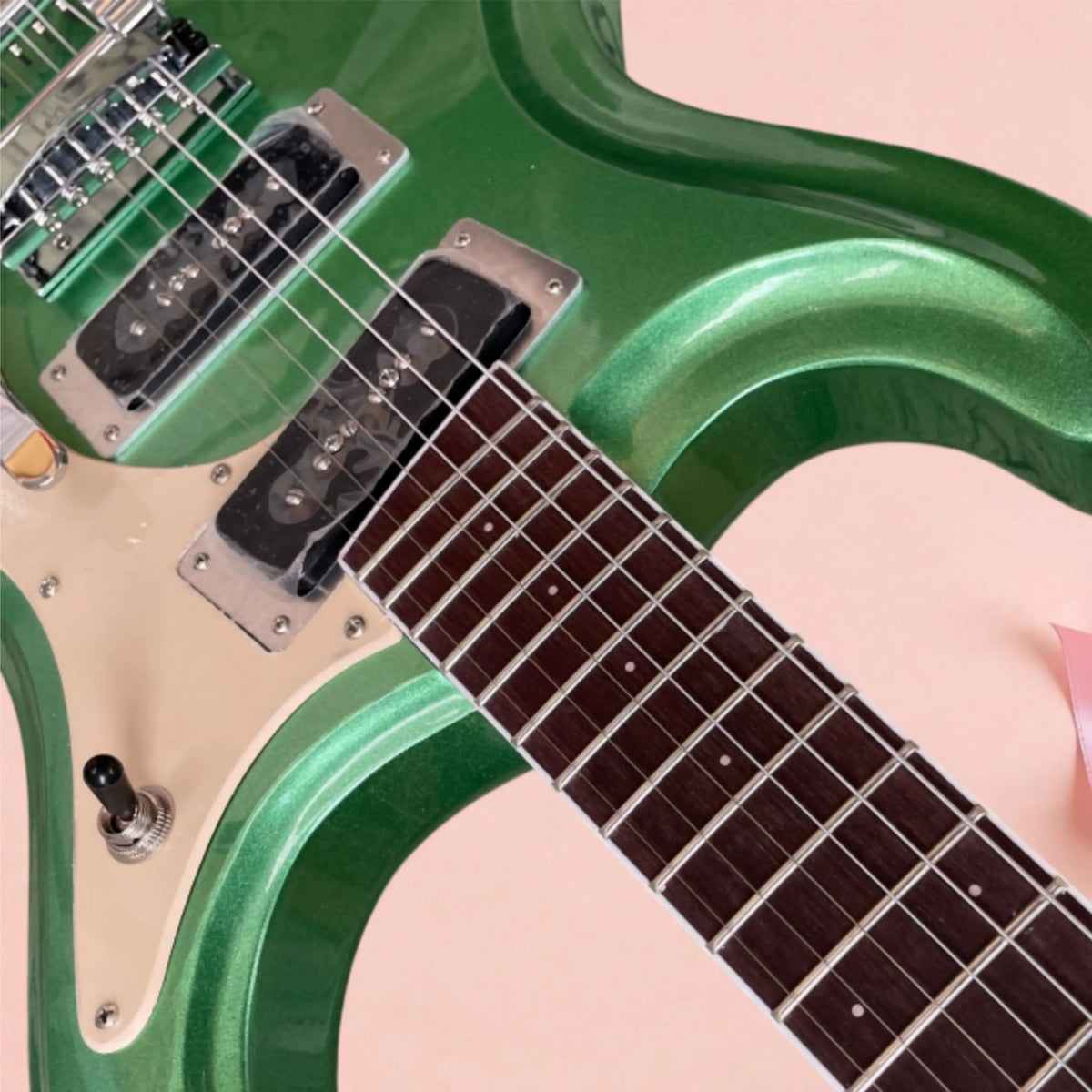 Guitarra eléctrica de 6 cuerdas, de color verde metálico, con herrajes plateados y placa protectora de color beige. Ideal para principiantes.