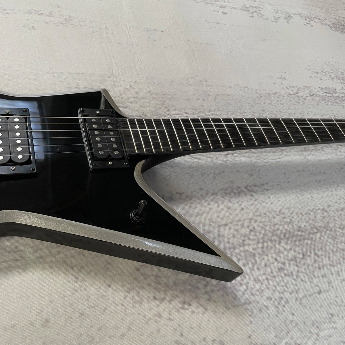 Guitarra eléctrica Star V, acabado en negro brillante con ribete plateado, doble sistema de captación de alta ganancia, trémolo con doble sistema de bloqueo, mástil de ébano, 22 trastes.
