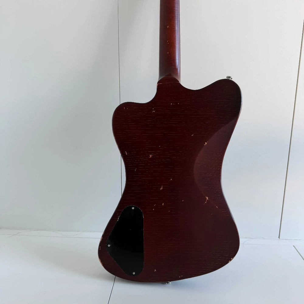 Guitarra eléctrica de cuerpo macizo con diseño único, acabado en color marrón envejecido y con efecto desgastado, tres pastillas de bobina simple y puente con trémolo.
