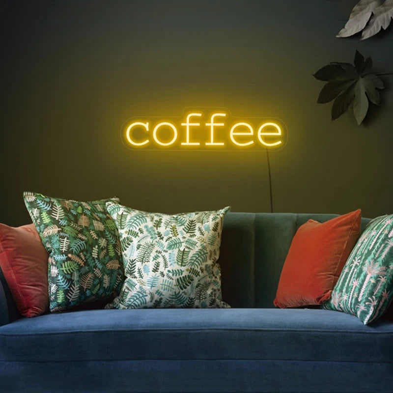 Letrero LED de neón con texto “coffee” en luz blanco cálido sobre pared.