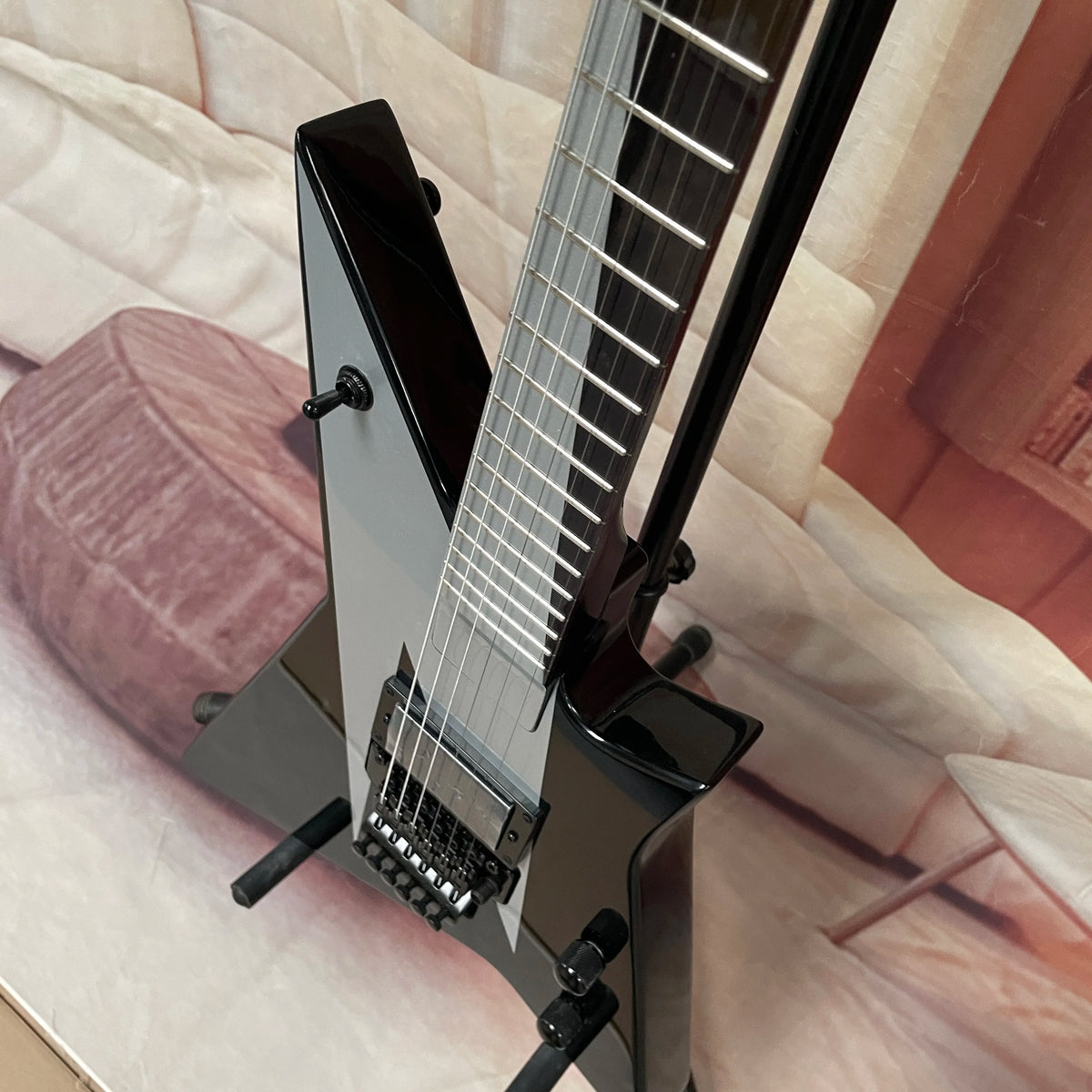 Guitarra eléctrica de 6 cuerdas, cuerpo negro con acabado plateado-gris, guitarra eléctrica con pastillas de doble bobina, guitarra eléctrica de forma única y no convencional.