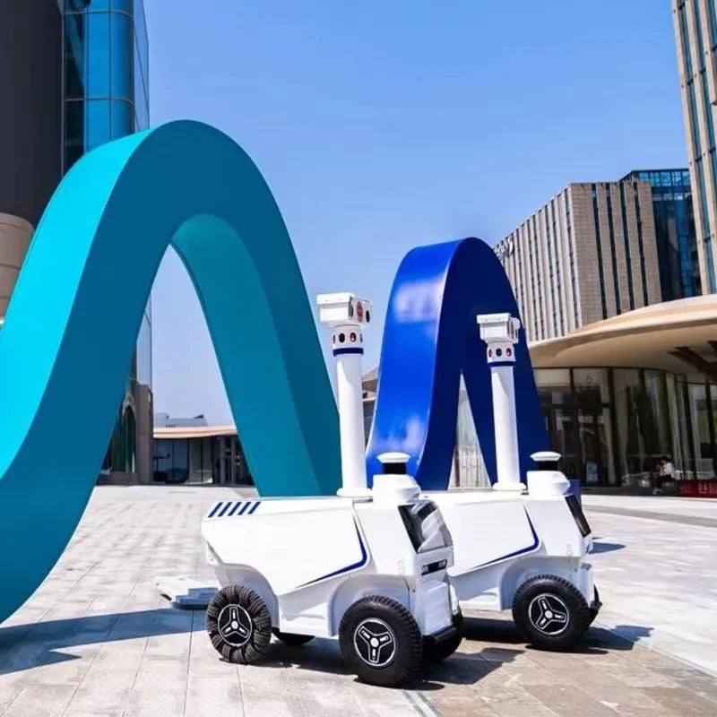 Robot de seguridad exterior blanco y azul con torreta giratoria y ruedas todoterreno
