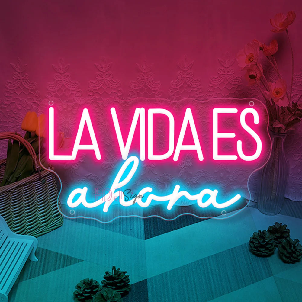 Letrero LED “LA VIDA ES ahora” con letras rosa y “ahora” azul claro