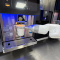 Robot barista automático con brazo blanco y taza sobre bandeja metálica