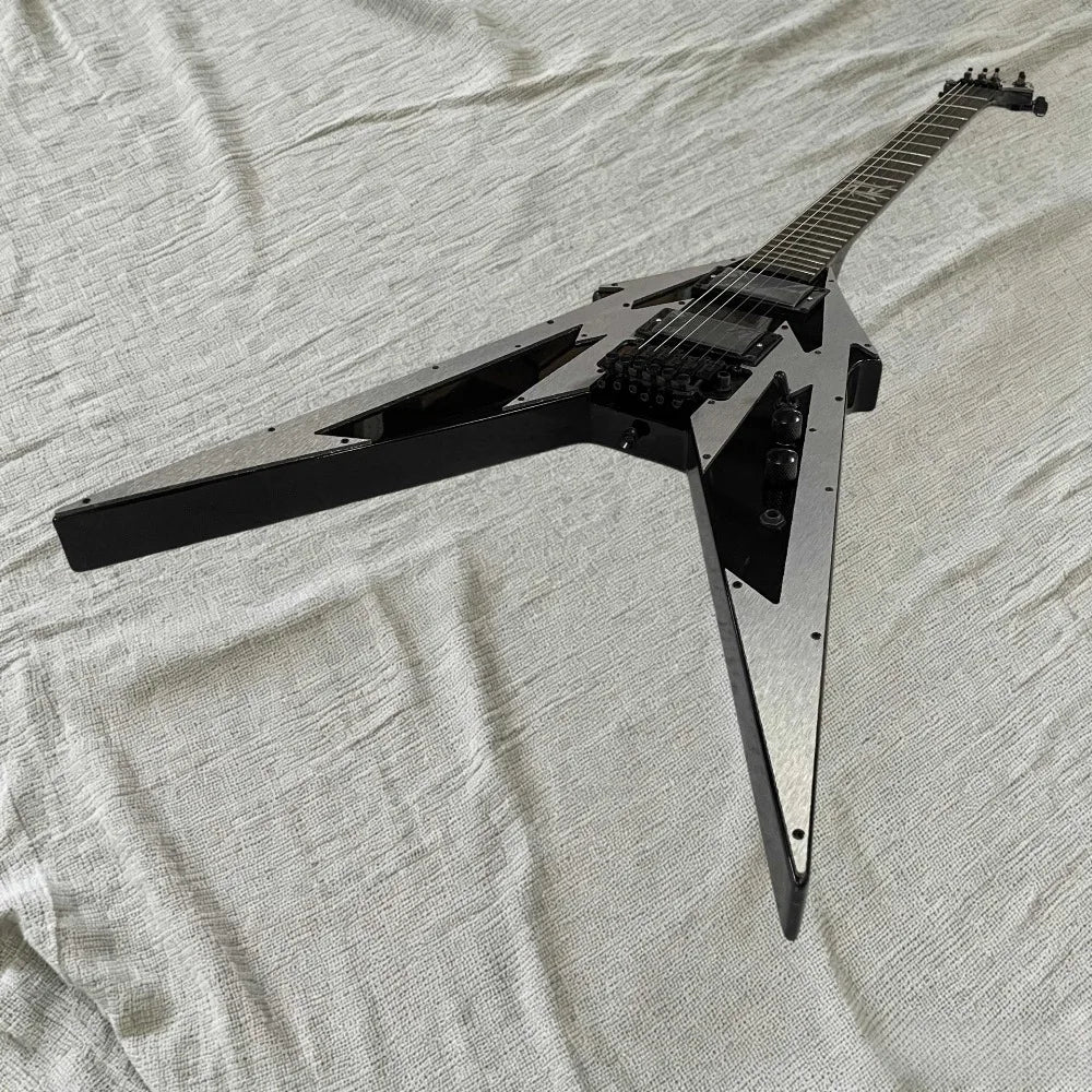 Guitarra eléctrica con forma de V, diseño geométrico en color plateado y negro, placa frontal de aluminio, puente con sistema de trémolo, pastillas HH, herrajes negros.
