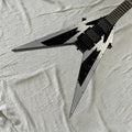 Guitarra eléctrica con forma de V, diseño geométrico en color plateado y negro, placa frontal de aluminio, puente con sistema de trémolo, pastillas HH, herrajes negros.
