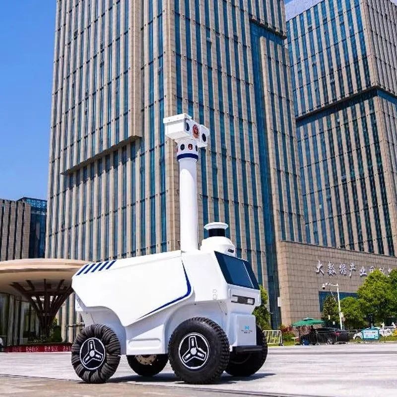 Robot de seguridad exterior blanco con mástil alto, torreta de sensores y ruedas todoterreno