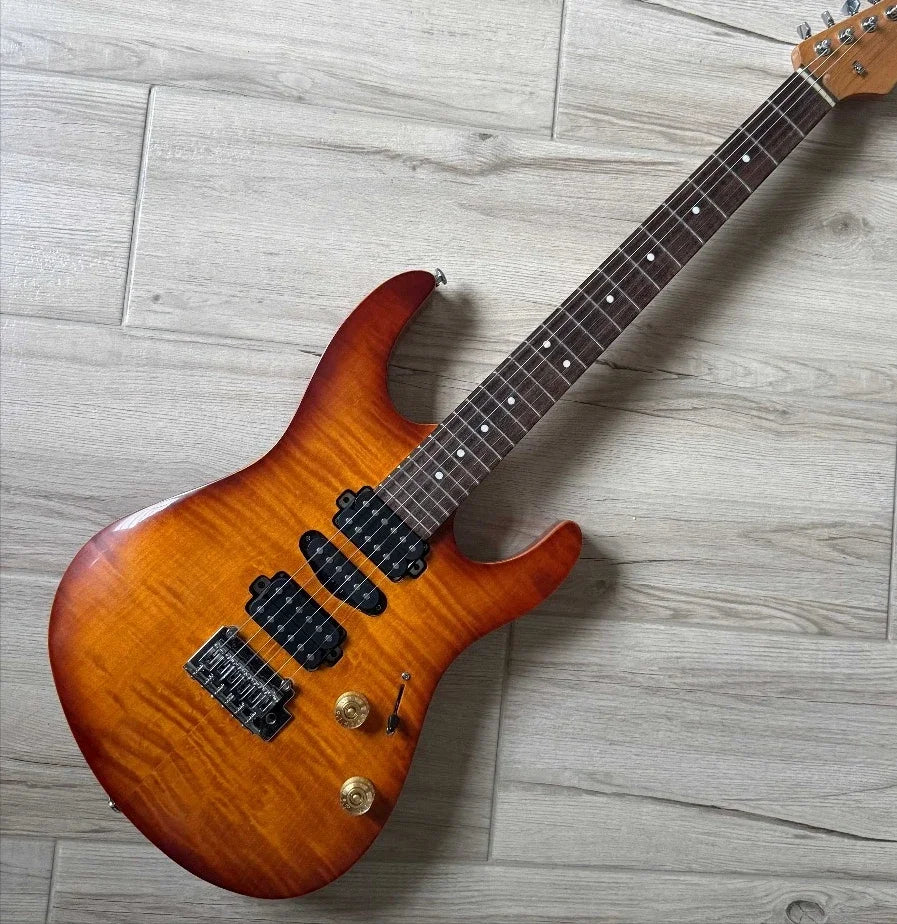 Guitarra eléctrica de cuerpo macizo de estilo moderno, con pastillas humbucker HH, tapa de chapa de arce flameado y acabado degradado tipo «sunburst».