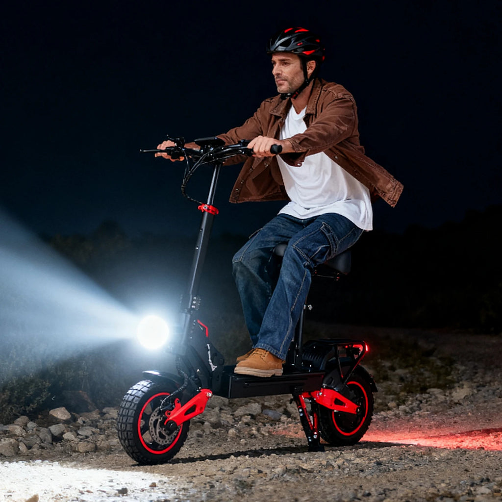 Patinete eléctrico rojo con luces delanteras y neumáticos grandes, sobre terreno rocoso