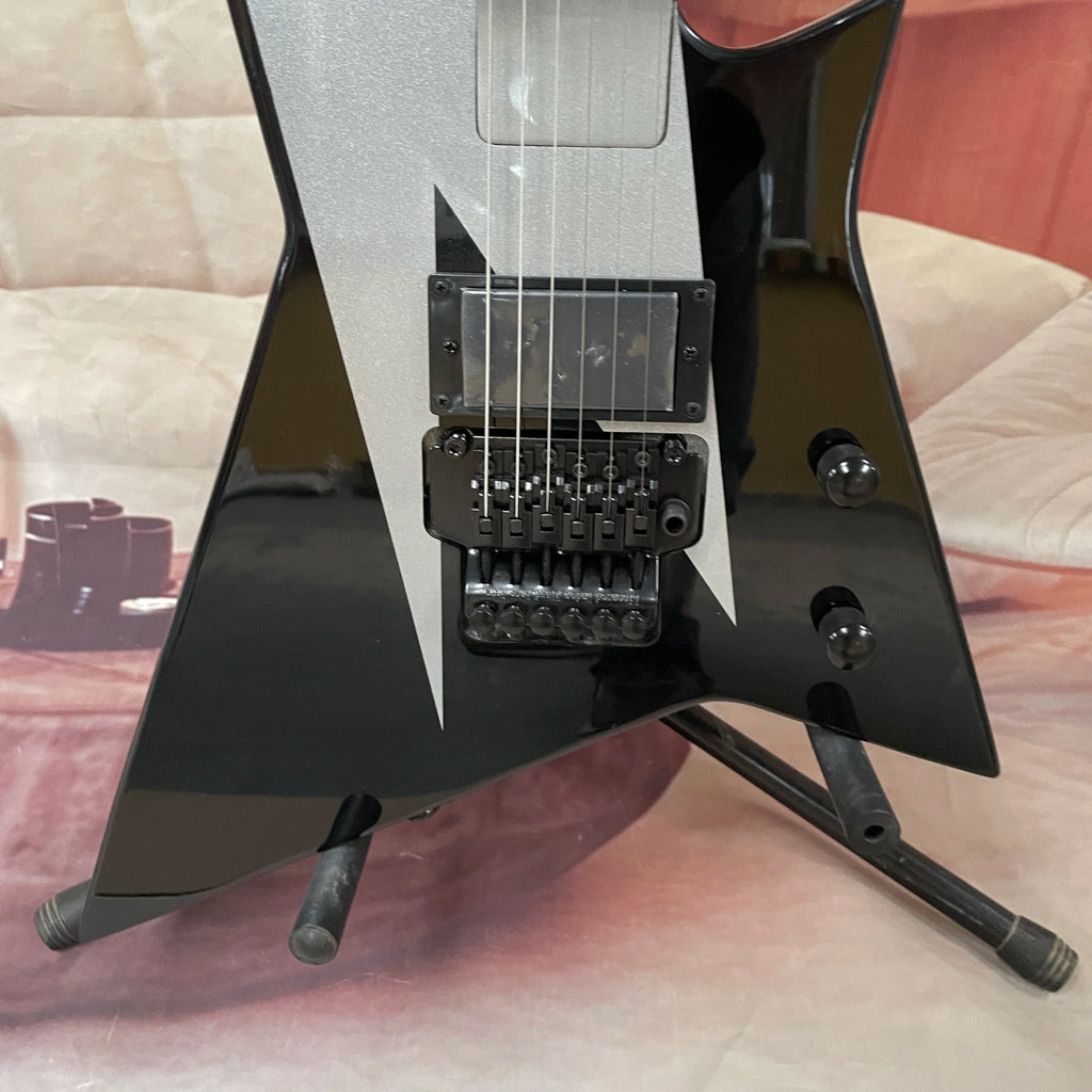 Guitarra eléctrica de 6 cuerdas, cuerpo negro con acabado plateado-gris, guitarra eléctrica con pastillas de doble bobina, guitarra eléctrica de forma única y no convencional.