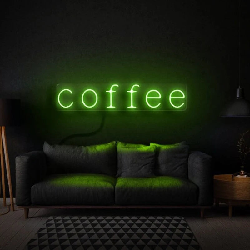 Letrero LED de neón con texto “coffee” en luz verde sobre pared oscura.