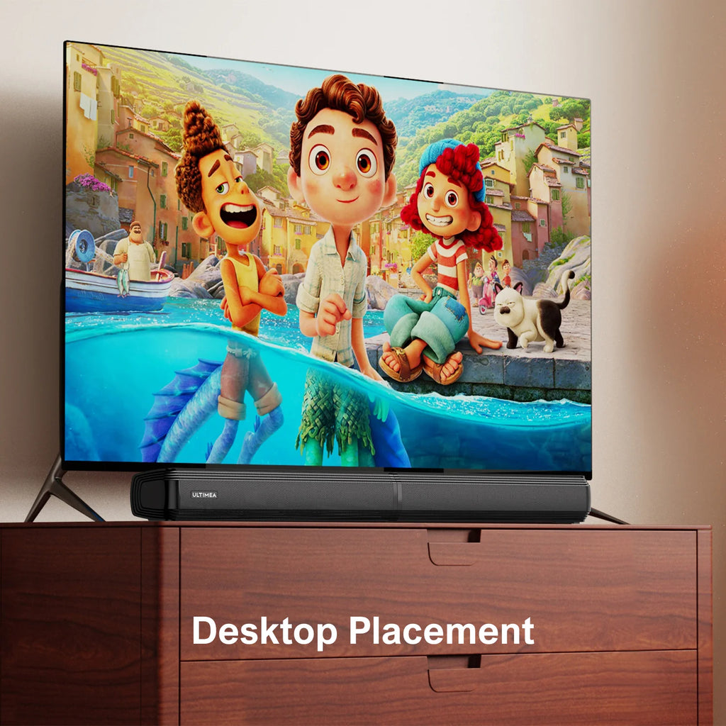 Barra de sonido ULTIMEA negra sobre mesa, junto a una TV de pantalla plana