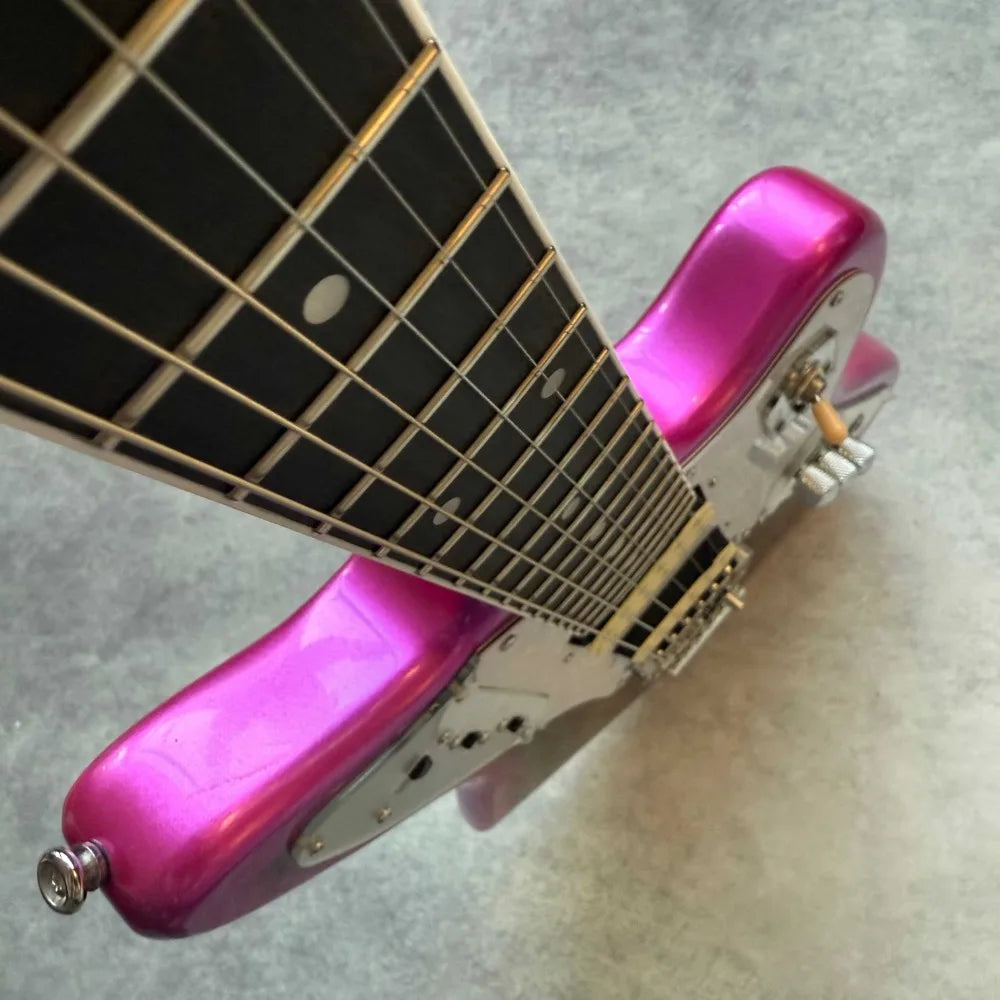Guitarra eléctrica de cuerpo negro con acabado metálico púrpura, protector de cuerdas blanco nacarado, pastillas HH, sistema de trémolo de estilo vintage, cuerpo sólido de diseño offset.