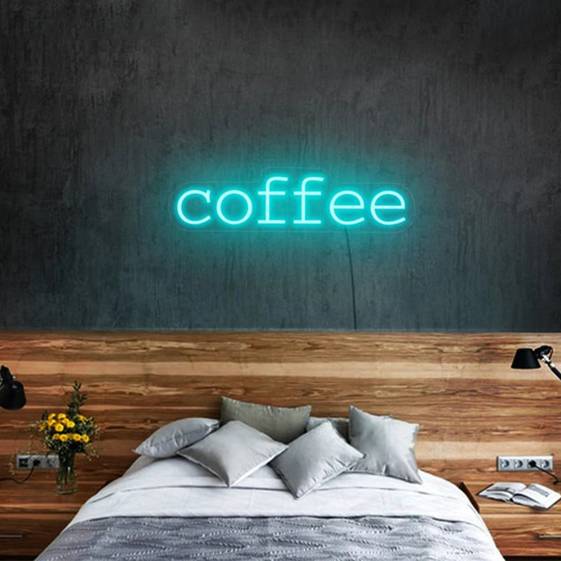 Letrero LED de neón con texto “coffee” en luz azul claro sobre pared.