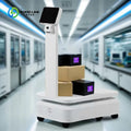 Robot de entrega con IA, base blanca con ruedas y torre con pantalla negra arriba.