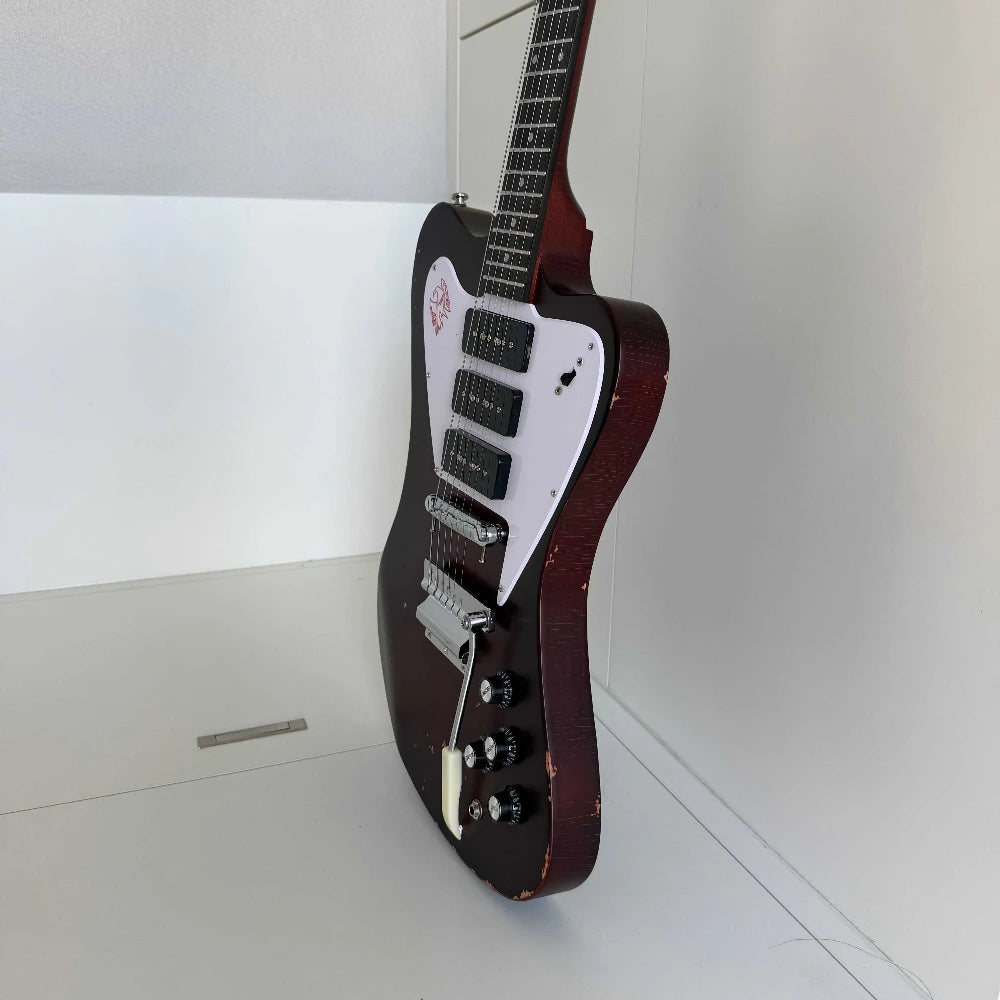 Guitarra eléctrica de cuerpo macizo con diseño único, acabado en color marrón envejecido y con efecto desgastado, tres pastillas de bobina simple y puente con trémolo.