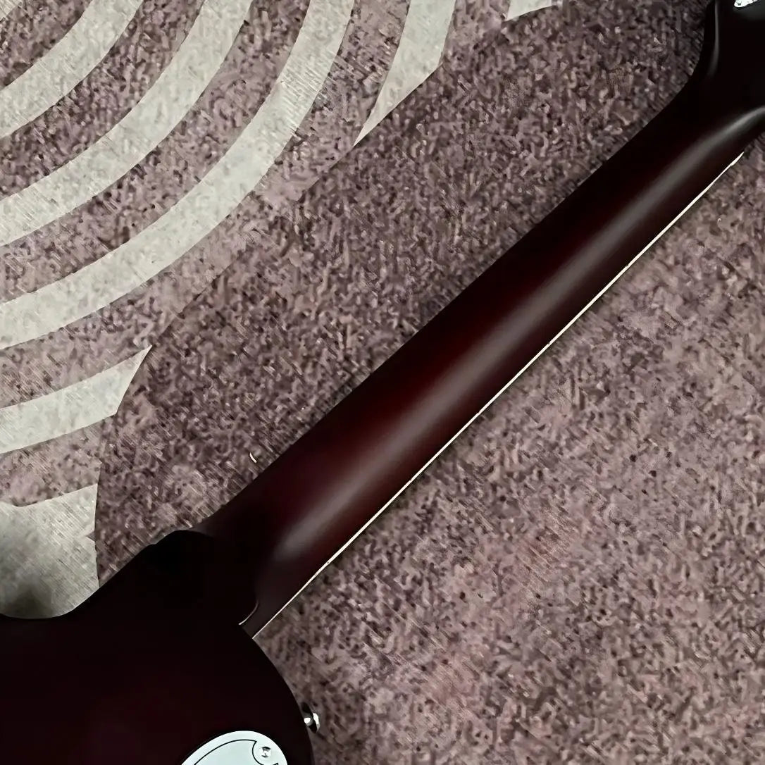 Guitarra eléctrica con tapa de aluminio grabado, cuerpo de caoba, incrustaciones de ébano en la tapa, doble sistema de pastillas humbucker, puente fijo cromado, 22 trastes.