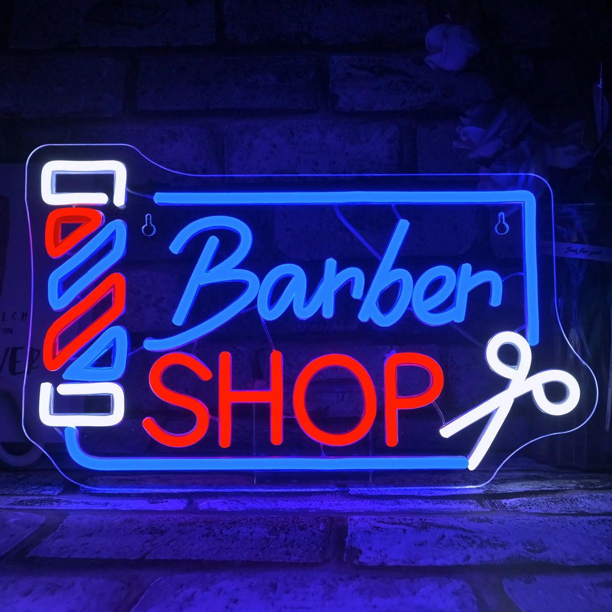 Rótulo de neón «Barber SHOP» con letras multicolor y poste de rayas iluminado