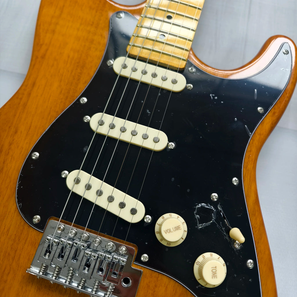 Guitarra eléctrica de madera natural con diapasón de arce, guardapalos negro SSS, bobina y trémolo. En stock.