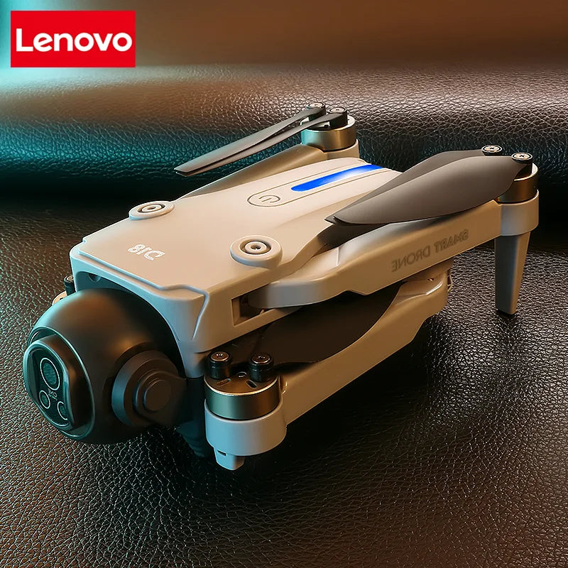 Dron RC gris claro con cámara y luces LED azules; cuerpo compacto y hélices visibles.