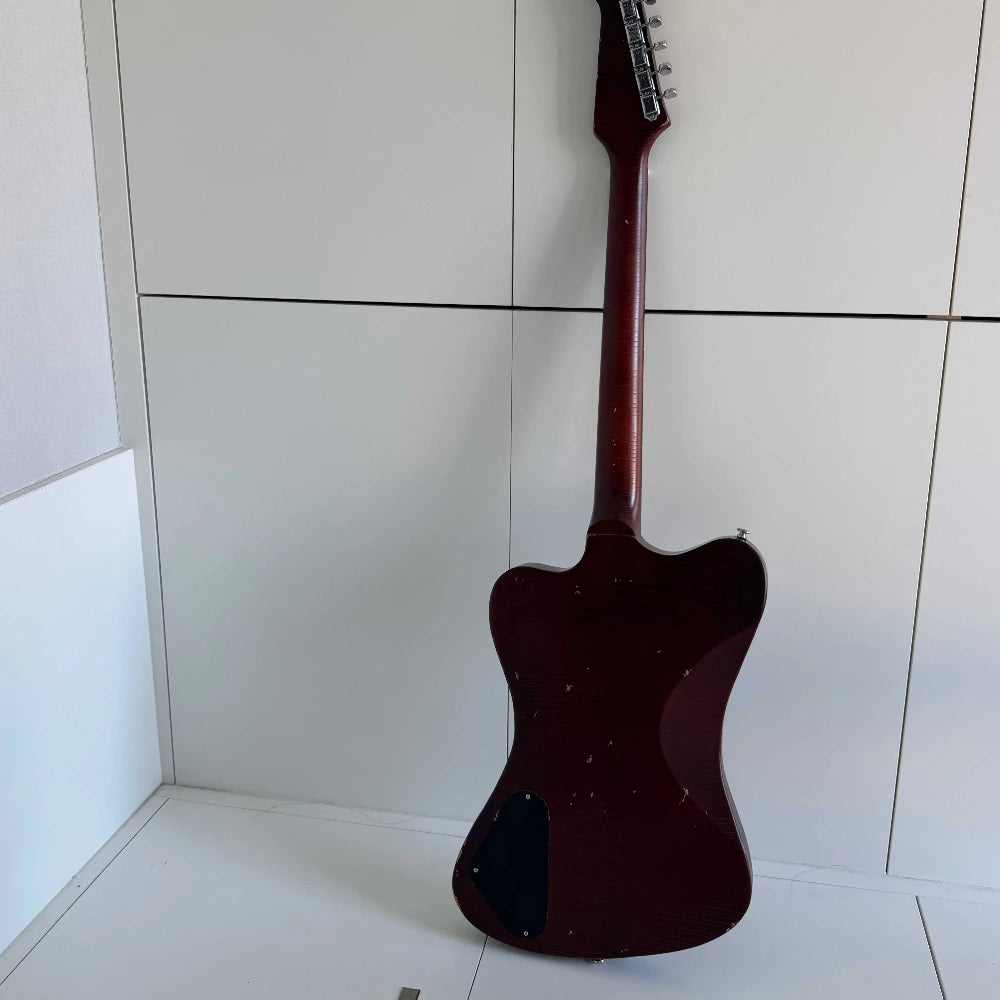 Guitarra eléctrica de cuerpo macizo con diseño único, acabado en color marrón envejecido y con efecto desgastado, tres pastillas de bobina simple y puente con trémolo.