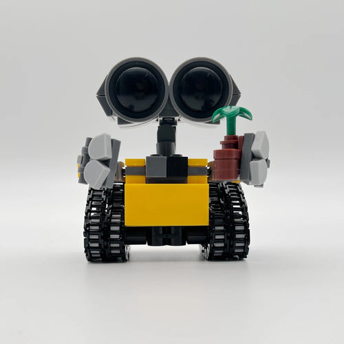 Figura de robot mini de bloques con torso amarillo y ruedas negras, con detalle verde