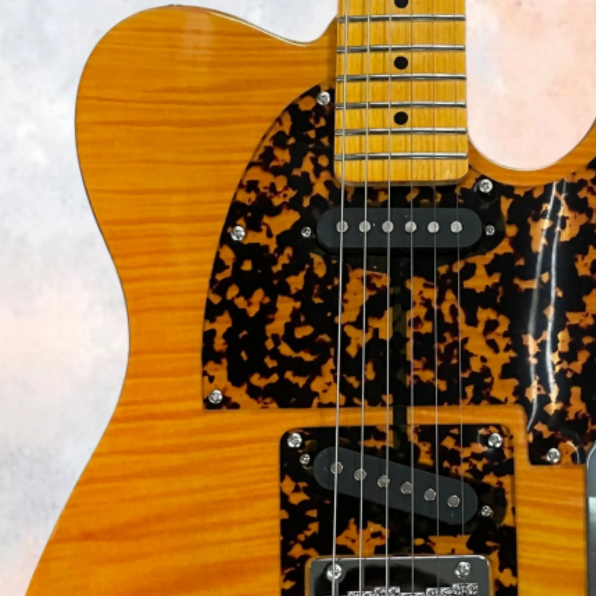 Guitarra eléctrica de cuerpo macizo en color ámbar, con pastillas de acero inoxidable, diapasón de arce y herrajes plateados. Guitarra con un encanto retro, ideal para tocar y coleccionar.