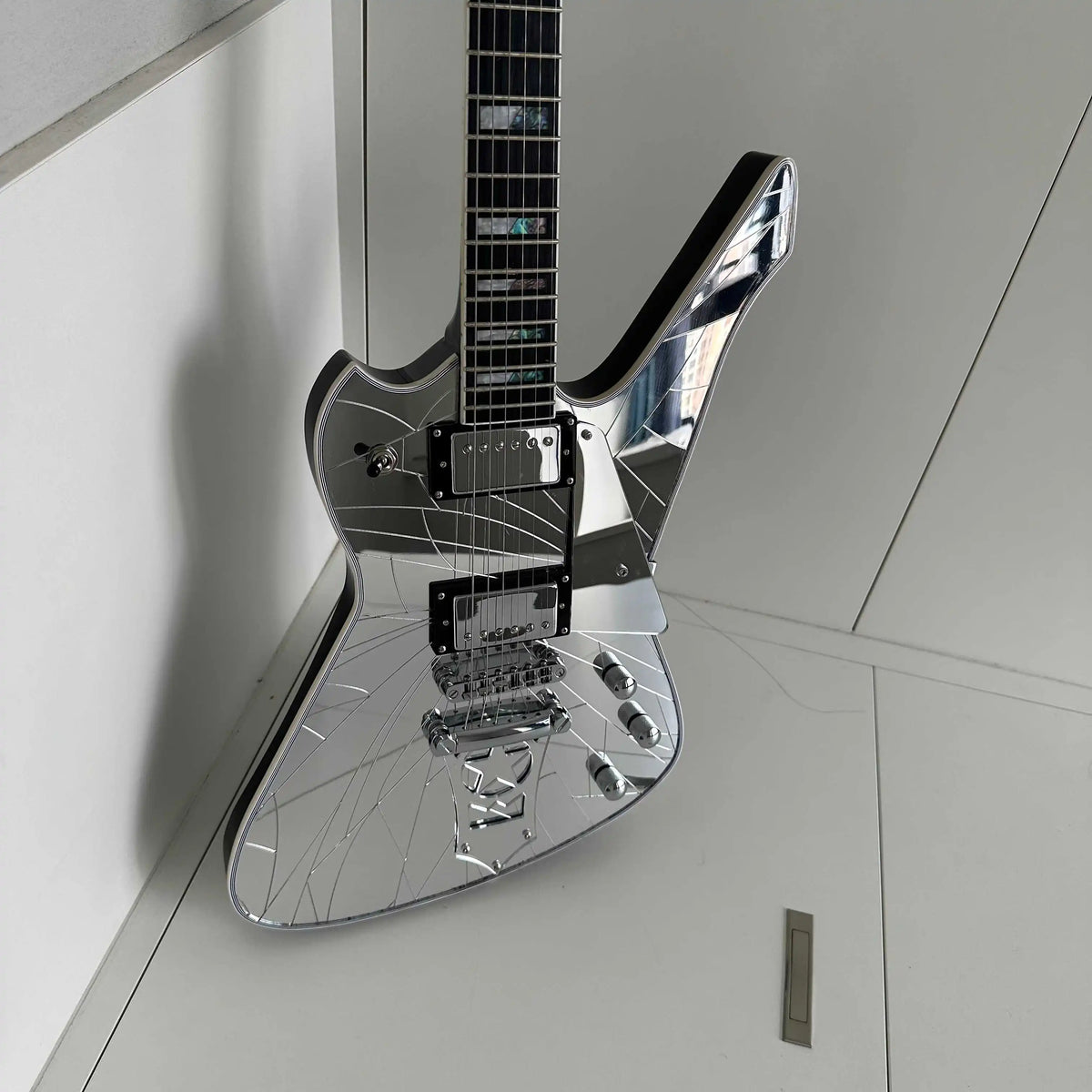 Guitarra eléctrica asimétrica, incrustaciones de perlas de abulón en forma de bloque dividido, cuerpo y tapa trasera con acabado espejado, protector de cuerdas con forma de estrella, pastillas HH.