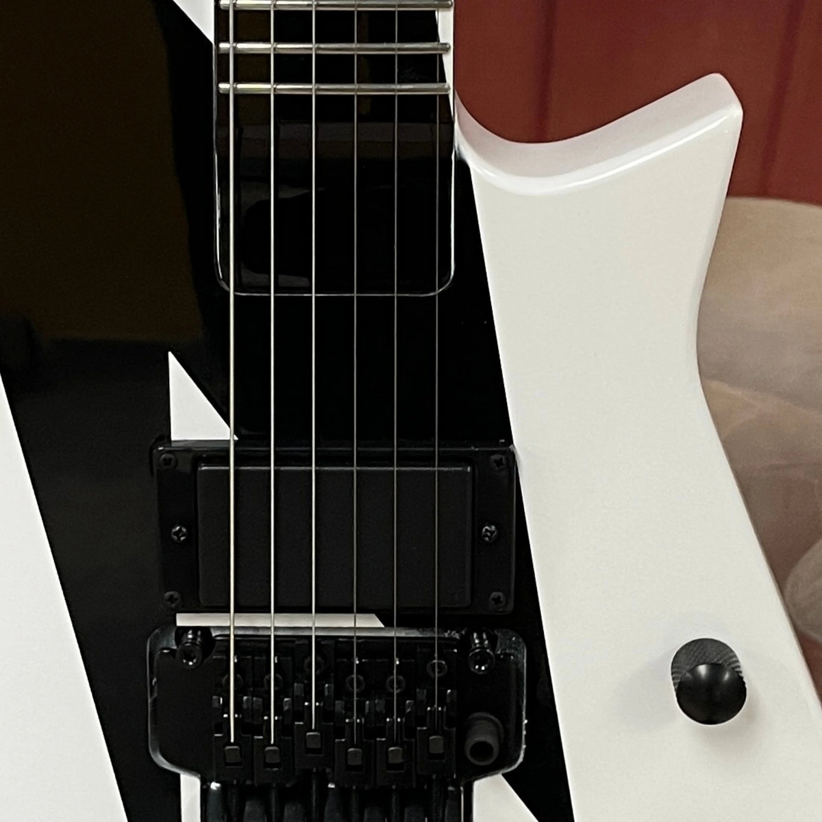 Guitarra eléctrica de 6 cuerdas con acabado en blanco y negro, cuerpo de caoba, herrajes negros —ideal para presentaciones en escenario.