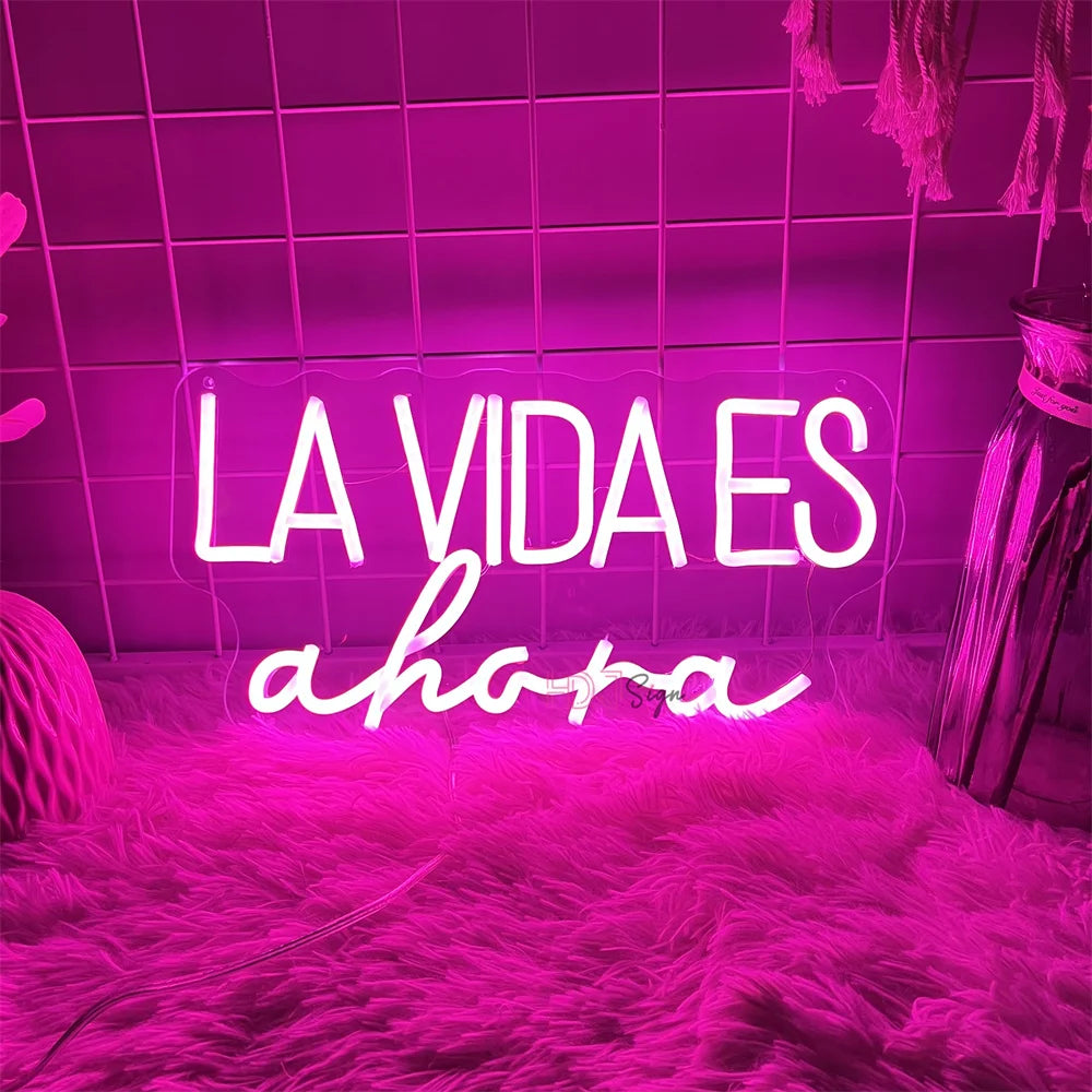 Letrero LED luminoso “LA VIDA ES ahora” con brillo rosa y borde transparente
