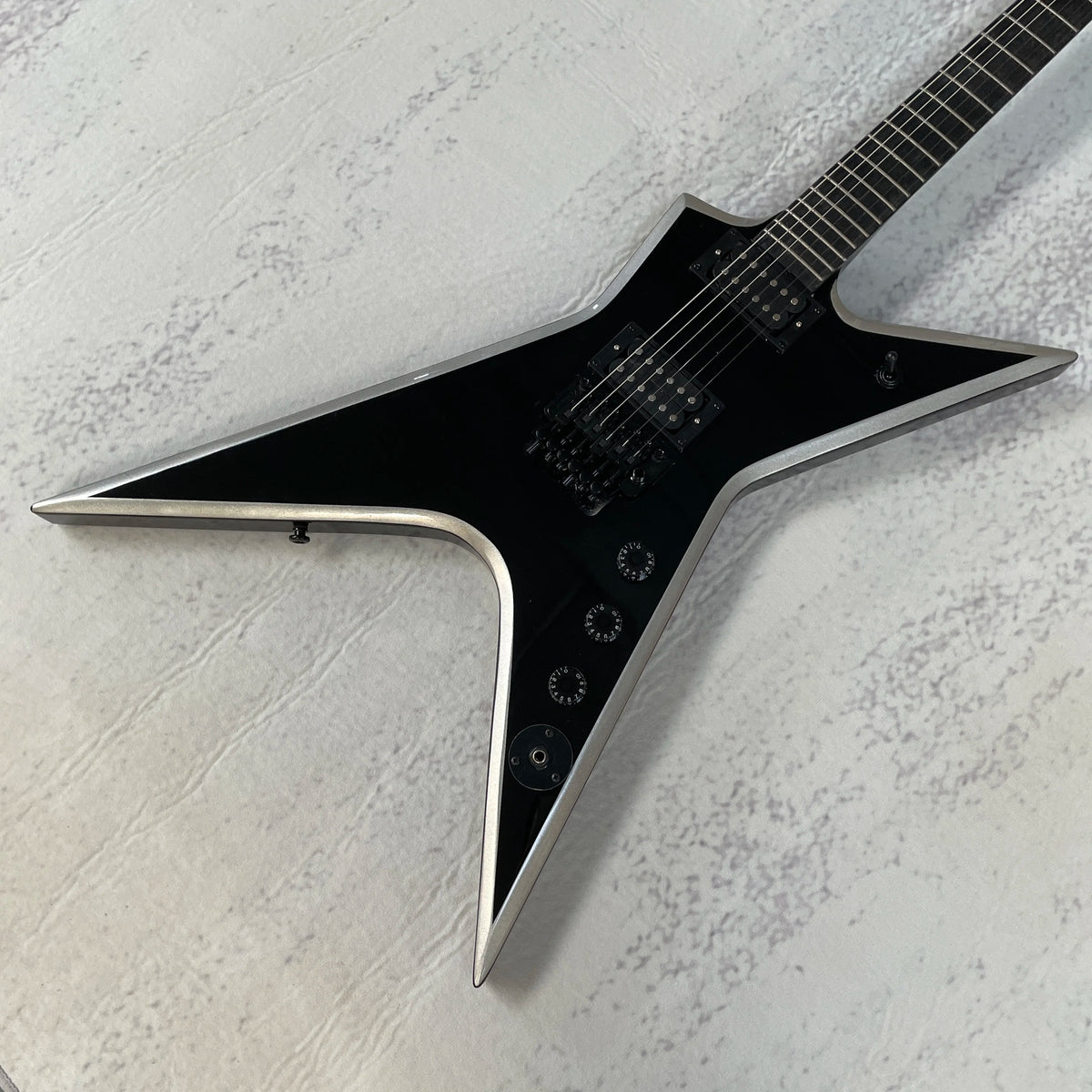 Guitarra eléctrica Star V, acabado en negro brillante con ribete plateado, doble sistema de captación de alta ganancia, trémolo con doble sistema de bloqueo, mástil de ébano, 22 trastes.