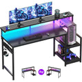 Escritorio gamer negro con textura tipo fibra de carbono y luces LED RGB, con estantes