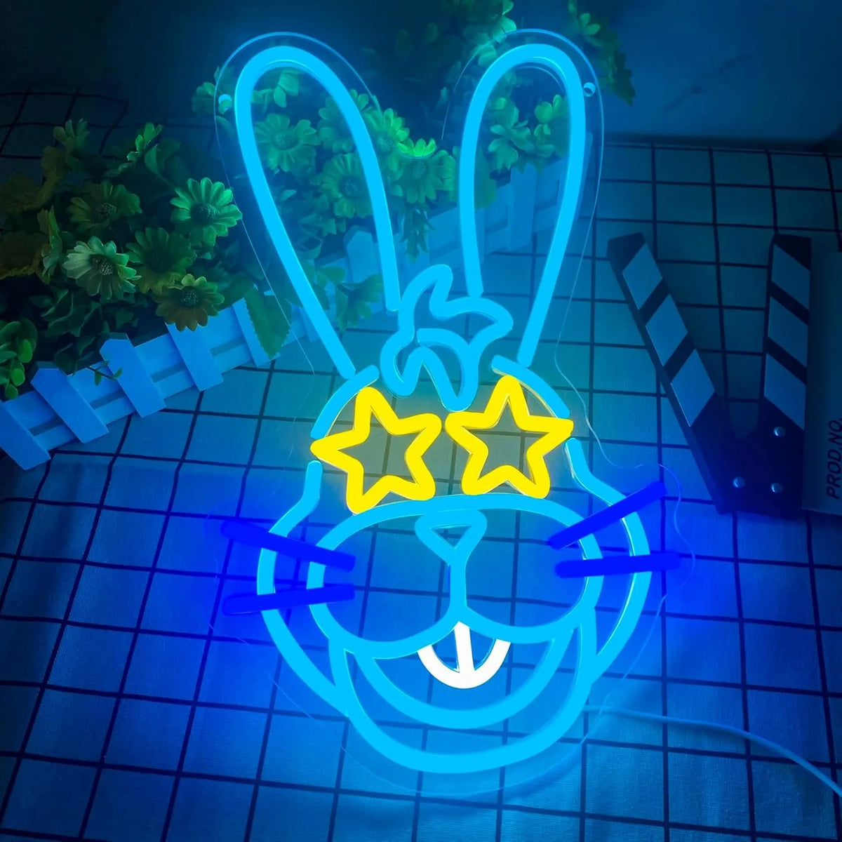 Letrero de neón de conejo azul con tres estrellas amarillas y aro decorativo.