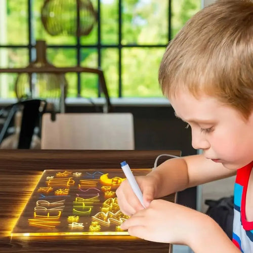 Pizarra LED de vidrio con escritura amarilla, niño usando marcador de color