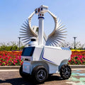 Robot de seguridad exterior blanco con base sobre ruedas y sensores en la parte superior